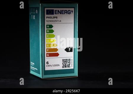 Picture of an EU energy label on a package of a lightbulb of philips isolated on a black background. EU Directive 92/75/EC established an energy consu Stock Photo