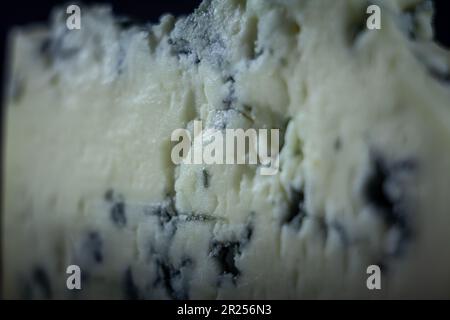 Picture of a macro shot of a slice of french blue cheese, or fromage bleu. Blue cheese is semi-soft cheese with a sharp, salty flavor. It is made with Stock Photo