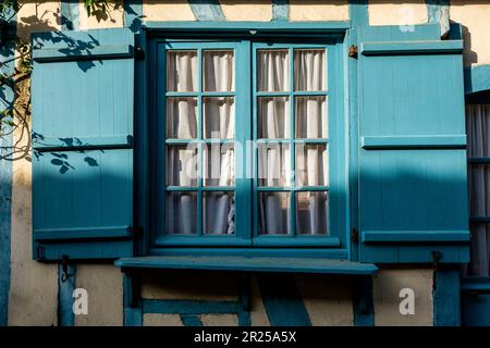 Gerberoy is ont of the most beautiful village of France - Man walking in the street - Blue Shutters | Gerberoy avec ses rues pavees typiques, ses toit Stock Photo