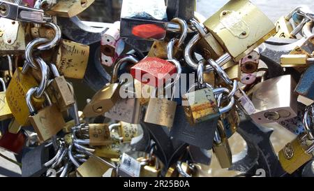 A close up shot of many locks clicked together on a black iron fence in Prague. Stock Photo