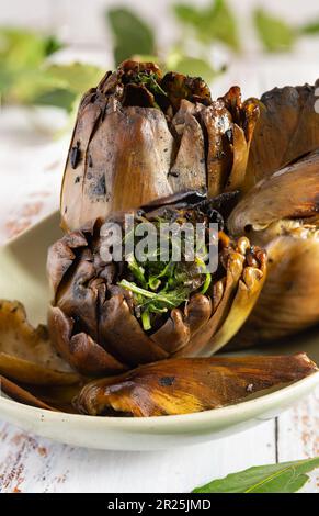 Grilled artichokes seasoned with olive oil, parsley, garlic and black pepper Stock Photo