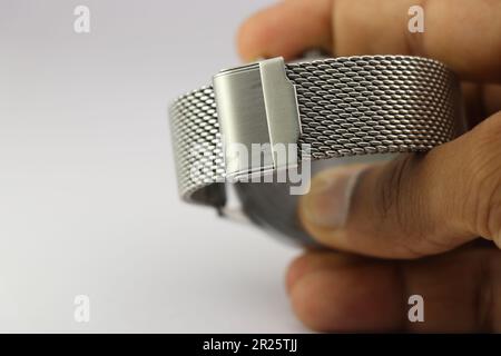 Stainless steel mesh strap of a watch held in the hand Stock Photo