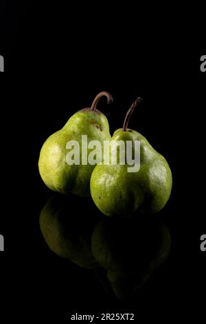 Two green ripe pears on a black background Stock Photo