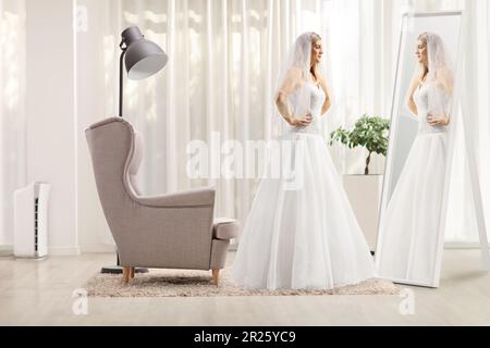 Full length profile shot of a bride standing in front of a mirror at home Stock Photo