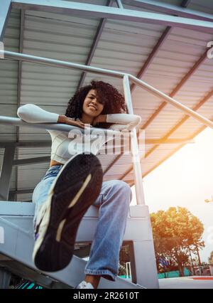 beautiful woman with dark and curly skin in a photo session on the court Stock Photo