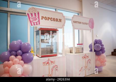 Popcorn and cotton candy machines. Carnival or party snacks booths. Popcorn and cotton candy for customers. Stock Photo