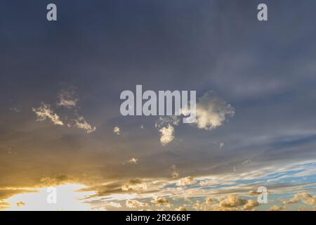 dark medium-high stratus clouds under which the sun shines through - Altostratus Stock Photo