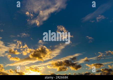 big sheep clouds are illuminated by sun from below - Altocumulus Stock Photo