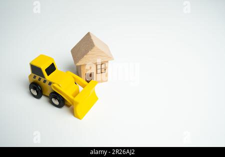 Bulldozer and house. Demolition services, land leveling and other land works for construction. Encroachment on private property. Illegal buildings. Vi Stock Photo