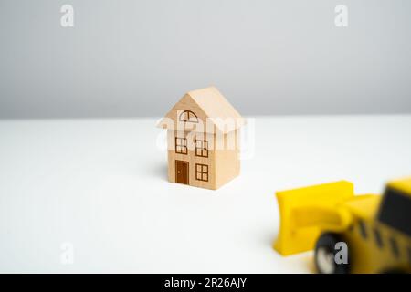 The bulldozer demolishes the house. Encroachment on private property. Illegal buildings and construction. Violation of building codes. Housing renovat Stock Photo