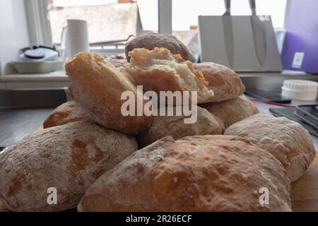 A pile of freshly baked ciabatta white crusty homemade rolls on a rustic wooden table, Top view, Side view. Stock Photo