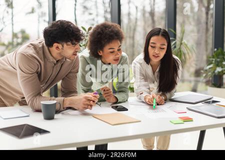 Multiethnic Business Team Brainstorming Standing At Table In Office Stock Photo
