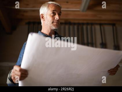 Hes a man with a plan. a senior man holding a blueprint. Stock Photo