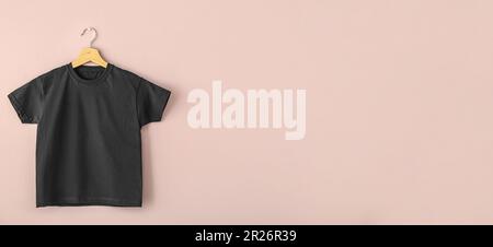Hanger with black man's t-shirt on pink background with space for text Stock Photo