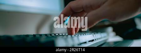 Low angle closeup view of male hand typing, working and using laptop computer. Wide view image. Stock Photo