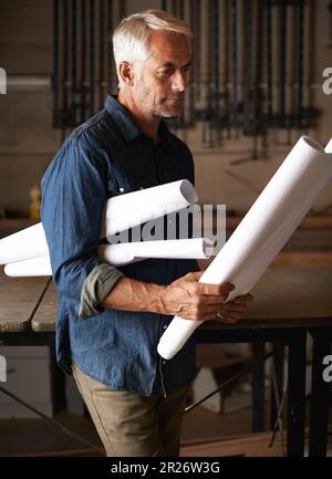 He knew that the best way to protect the future is to create it. senior man assessing his building plans. Stock Photo