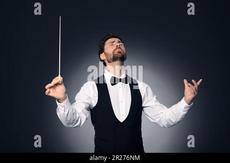 Professional conductor with baton on dark background, back view Stock ...