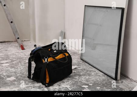 Bag tool and double glazing window on floor indoors Stock Photo