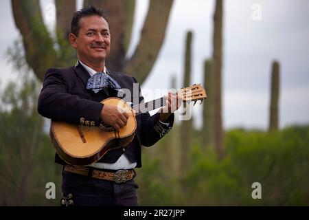 Hispanic man playing a vihuela in the Sonoran desert, part of a mariachi band. Tucson, Arizona. Close up. Stock Photo