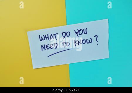 Concept of What Do You Need To Know? write on sticky notes isolated on Wooden Table. Stock Photo