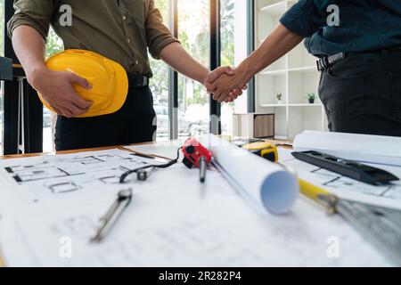 Professional Asian male engineer shaking hands with male architect after the meeting is over at office Stock Photo