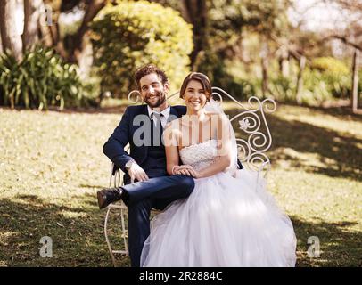 Portrait, wedding and couple sitting, outdoor and love with marriage, commitment and loving together. Face, bride and groom on a chair, loyalty and Stock Photo