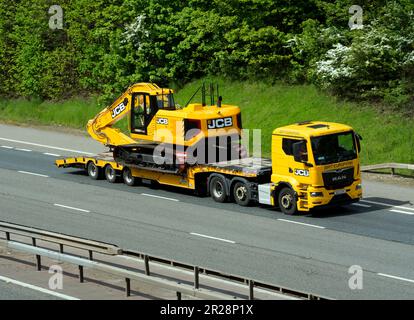 JCB low-loader lorry on the M40 motorway, Warwickshire, UK Stock Photo