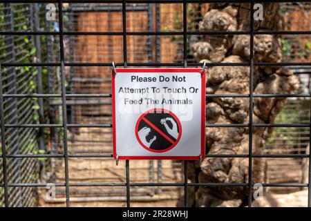 Please do not attempt to touch or feed the animals sign on the cage Stock Photo