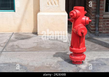 Red fire hydrant on sidewalk Stock Photo