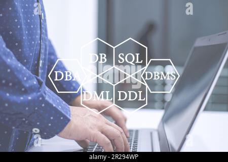 A man standing and typing a keyboard with a notebook computer on a white table for management database. Businessman using a laptop for work of money. Stock Photo