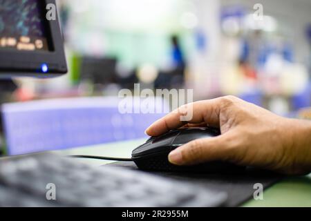 Close up a men working with computers on the glass table in the office Man's hand clicks the mouse To view financial information with the Internet. Ma Stock Photo