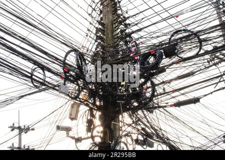 Electricity and cables, internet and surveillance cameras were neatly installed on poles. Many wires are entangled. Potentially dangerous Stock Photo