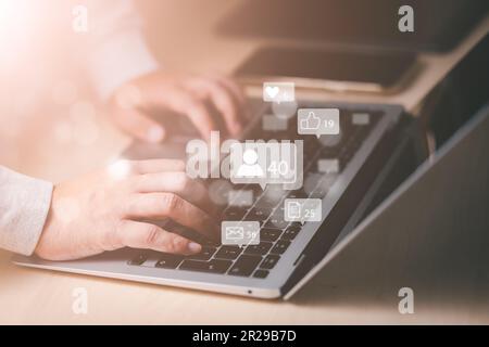 Businessman working with laptop, Social media and Marketing virtual icons screen concept, businessman typing keyboard with laptop computer on wooden d Stock Photo