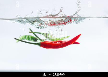 Red chilli, water splashes, solated on a white background Stock Photo