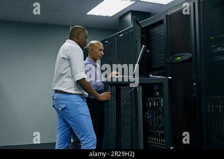 Server room, people or technicians coding on computer together for a cybersecurity glitch with teamwork. IT support code, collaboration or engineers Stock Photo