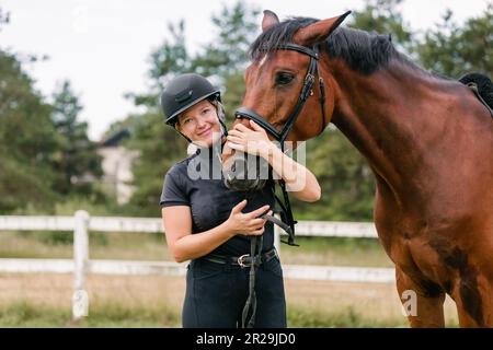 Female rider hand gently caressing beautiful thick red horse mane, close up shot. Equitation and animal lover concept. Stock Photo