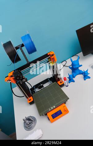 Modern 3d printer for creating 3d models and materials on the table in the laboratories next to the computer Stock Photo