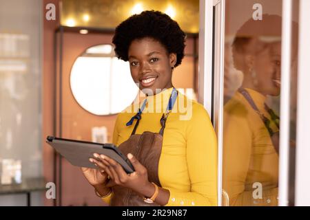 Portrait of happy african american female worker using tablet at jewellery shop Stock Photo