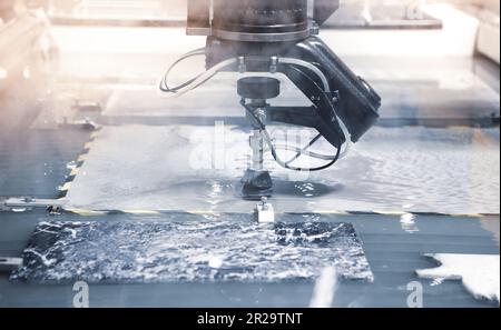 Modern CNC Abrasive water jet cutting machine using high pressure water jet cutting tile. Stock Photo