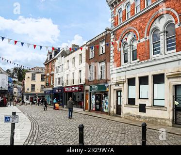 Shops on the edge of the Town Square in the ancient Cornish town of Launceston. Well known names on the high street. Stock Photo
