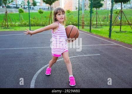 A girl plays streetball on a basketball court. Healthy lifestyle concept Stock Photo