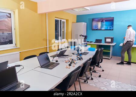 A bearded man in a modern robotics laboratory, immersed in research and surrounded by advanced technology and equipment. Stock Photo