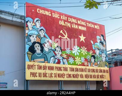 A Vietnam Communist Party propaganda roadside hoarding extolling all tyoes of people in the country to come together to build a modern nation. Transla Stock Photo