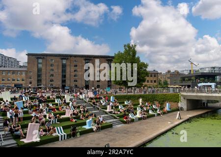 London, England-August 2022; High angle view of the Canalside Green Steps along the Regent’s Canal with people enjoying the sun Stock Photo