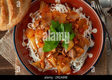 Hot Uighur dish served with herbs and flatbread. Stock Photo
