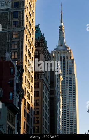 Madison Square North Historic District’s classic Fifth Avenue facades, viewed from 25th Street, lead up to Art Deco landmark Empire State Building. Stock Photo