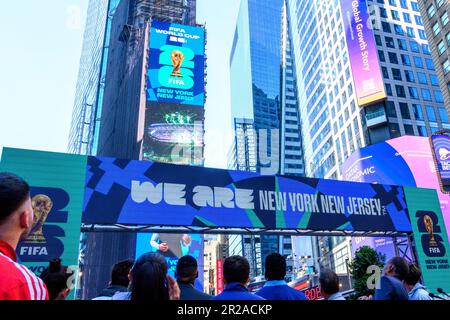 New York, USA. 18th May, 2023. People watch billboards displaying the official logos for the FIFA World Cup 2026 New York/New Jersey at a launch Event in Times Square. The event unveiled the official themes for the MetLife stadium matches: 'We are NYNJ' and 'We are 26'. The world's top soccer competition is already planning to host 8 matches in the New York/New Jersey area and the local organizers want to host the final game here too. Credit: Enrique Shore/Alamy Live News