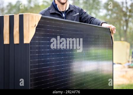 Person holding a set of several new solar panels Stock Photo
