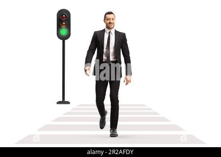 Full length portrait of a businessman crossing street at green traffic light isolated on white background Stock Photo