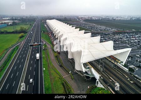 Aerial view of the Reggio Emilia AV Mediopadana station. Entrance and exit of trains. Traffic on the A1 highway. Reggio Emilia, Emilia Romagna, Italy, Stock Photo